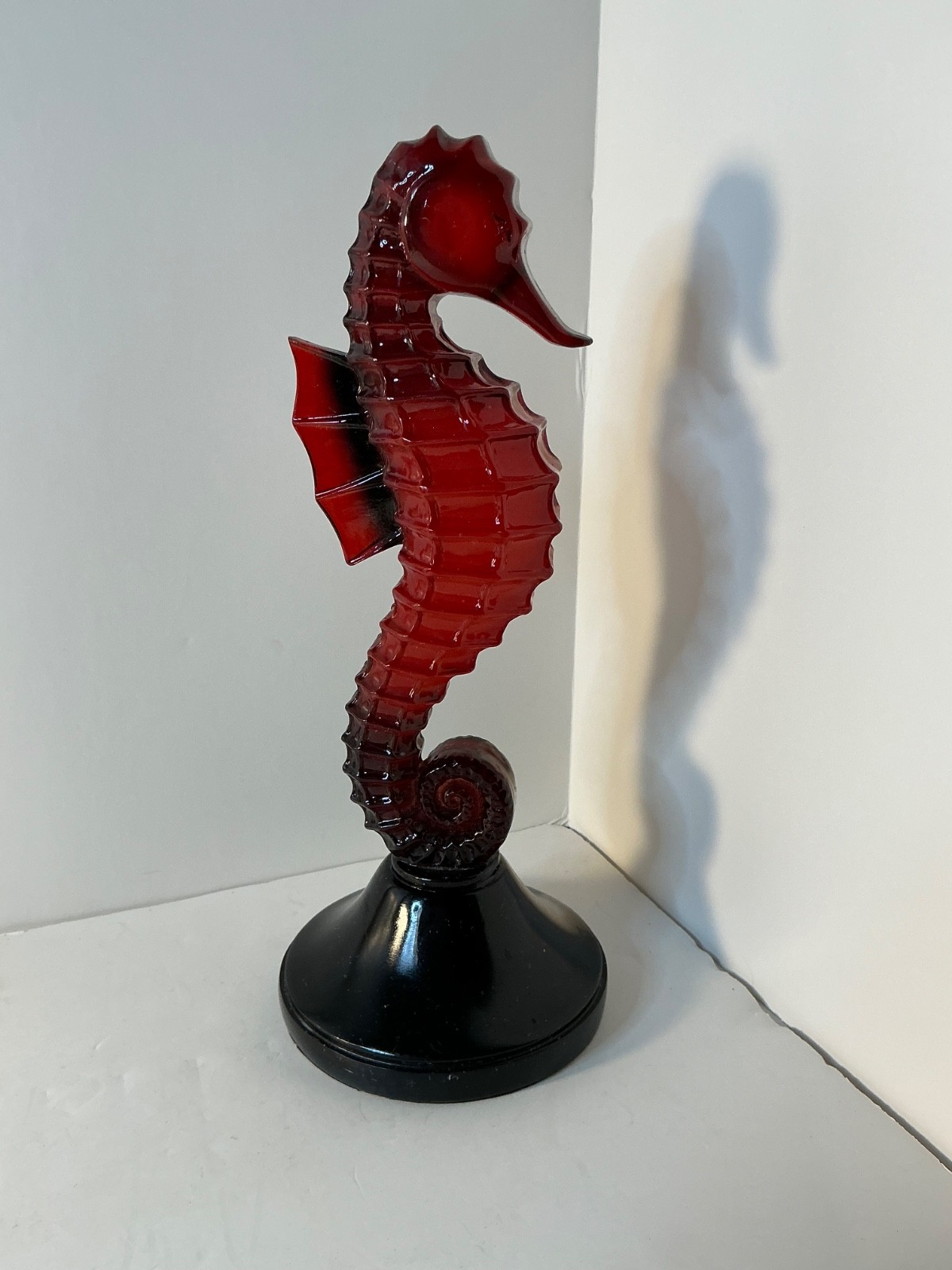 mid-century modern seahorse sculpture features a red lucite or acrylic body